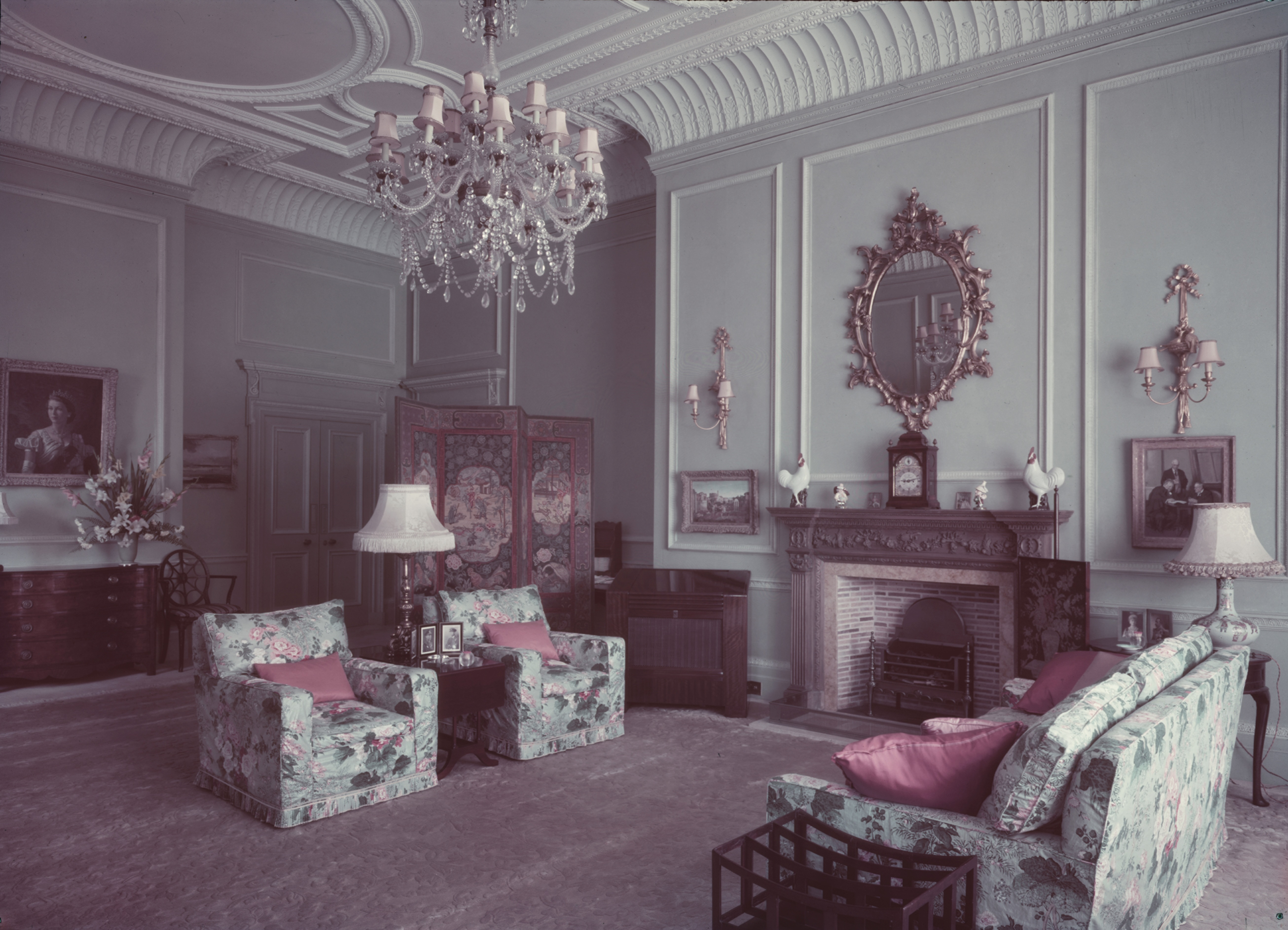 A room at Clarence House with blue, floral sofas and a chandelier