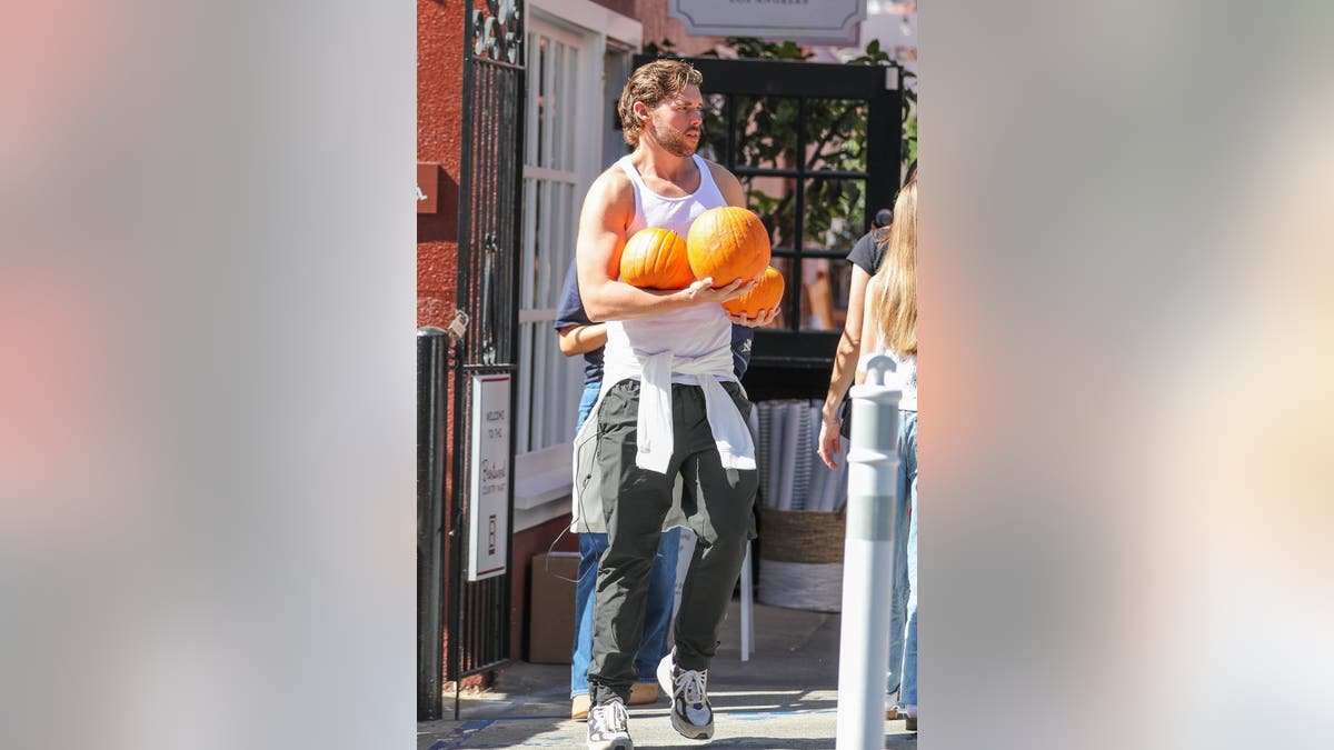 Christopher Schwarzenegger carries pumpkins.