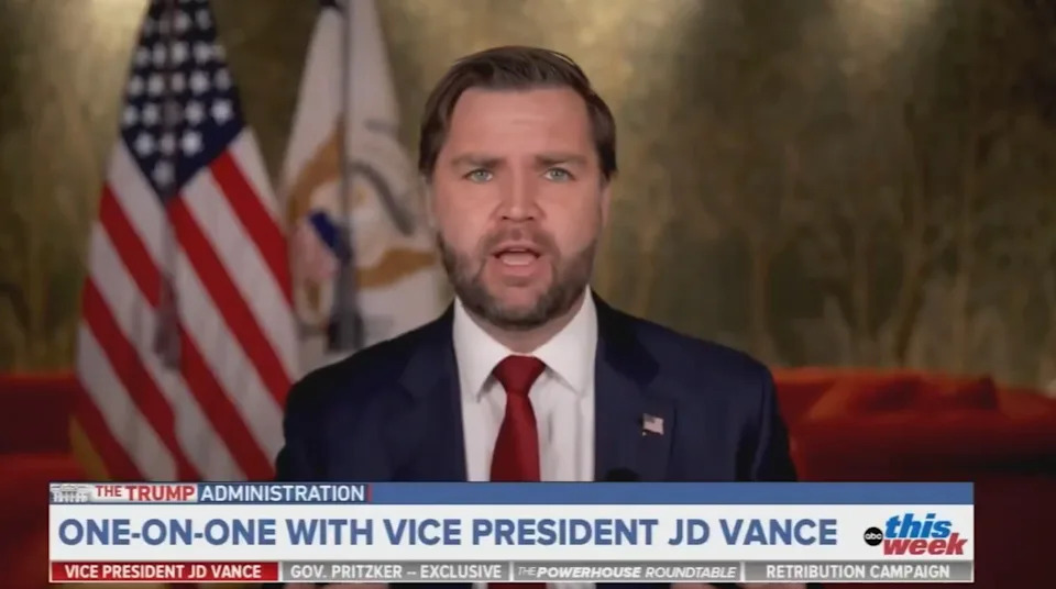 A man in a suit speaks in front of American flags with the text: "One-on-one with Vice President JD Vance" on a news program