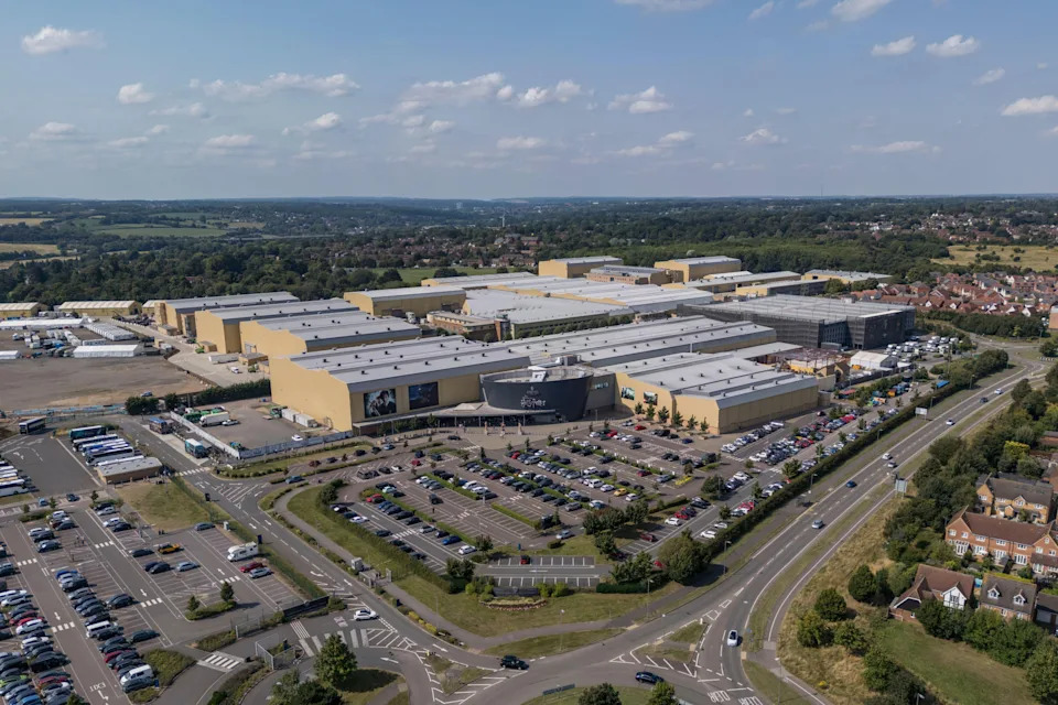 Aerial view of a large studio complex with multiple buildings, parking lots, and surrounding roads in a suburban area