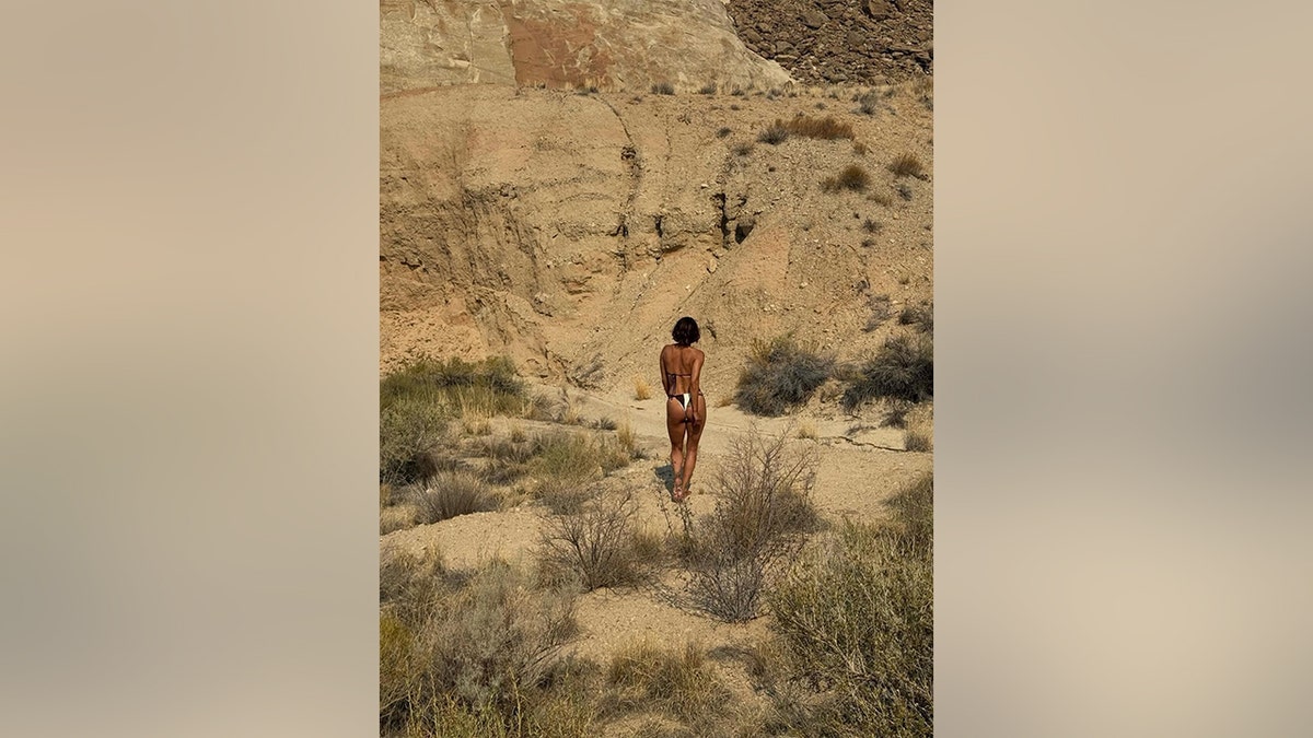 Halle Berry in a black and white string bikini walking away from the camera.