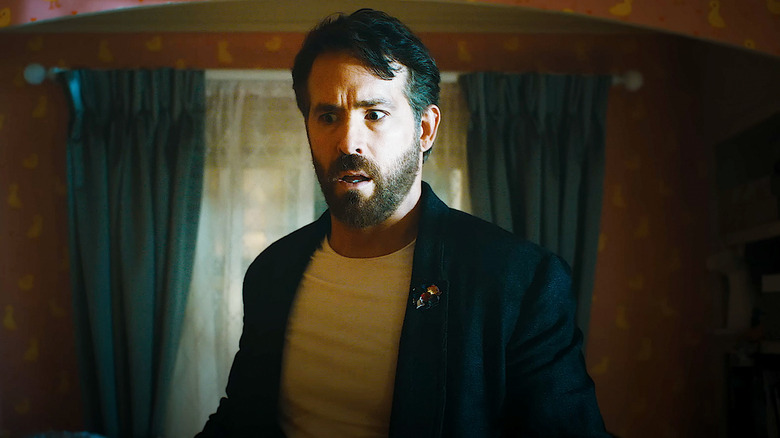 Ryan Reynolds' Cal looks worried as he stands in a room with a window in the background in IF