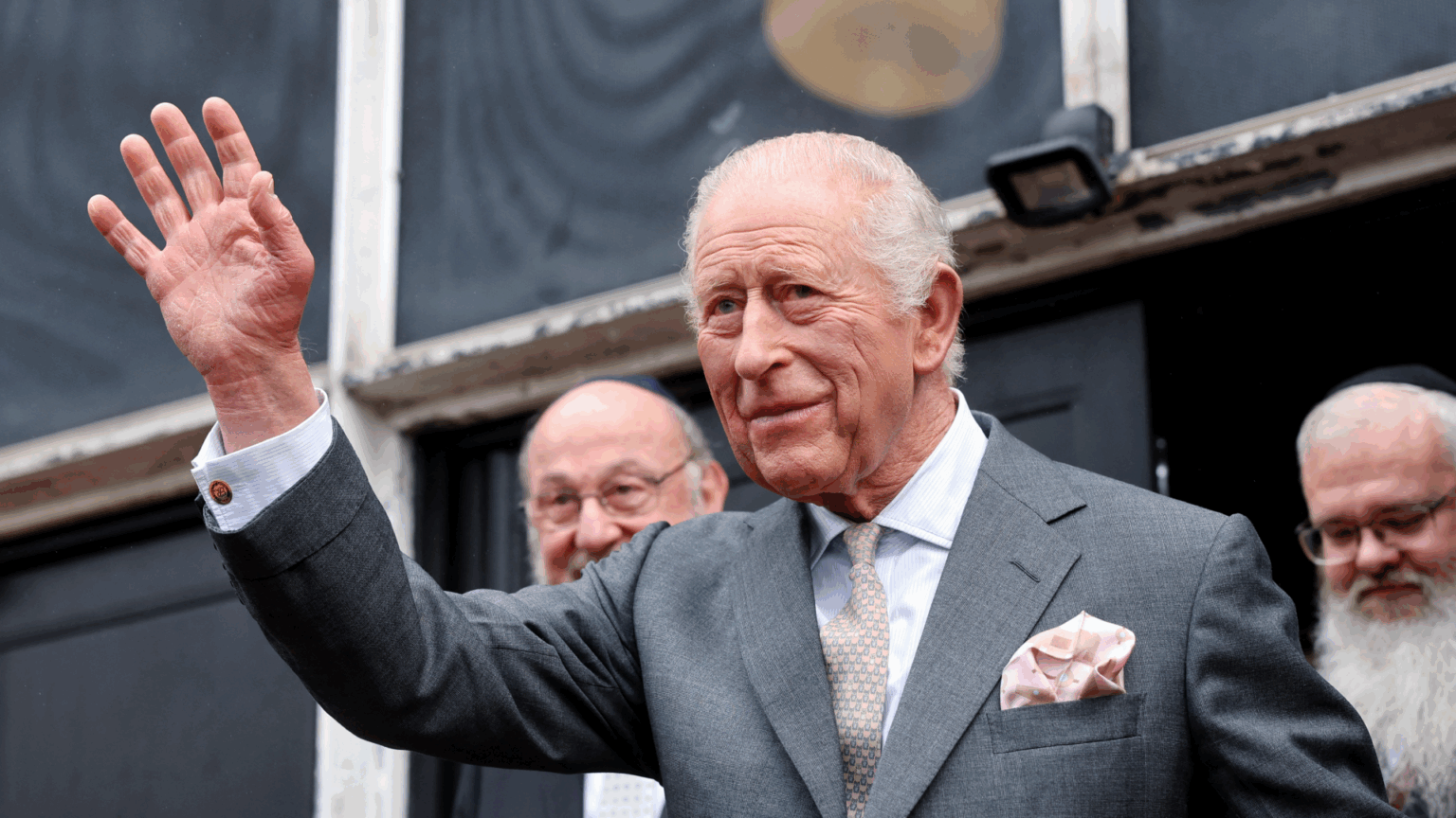 King Charles Is Focusing on “Duty and Service” Amid “Endless Stream of Embarrassment” For Royal Family King Charles wearing a gray suit and waving