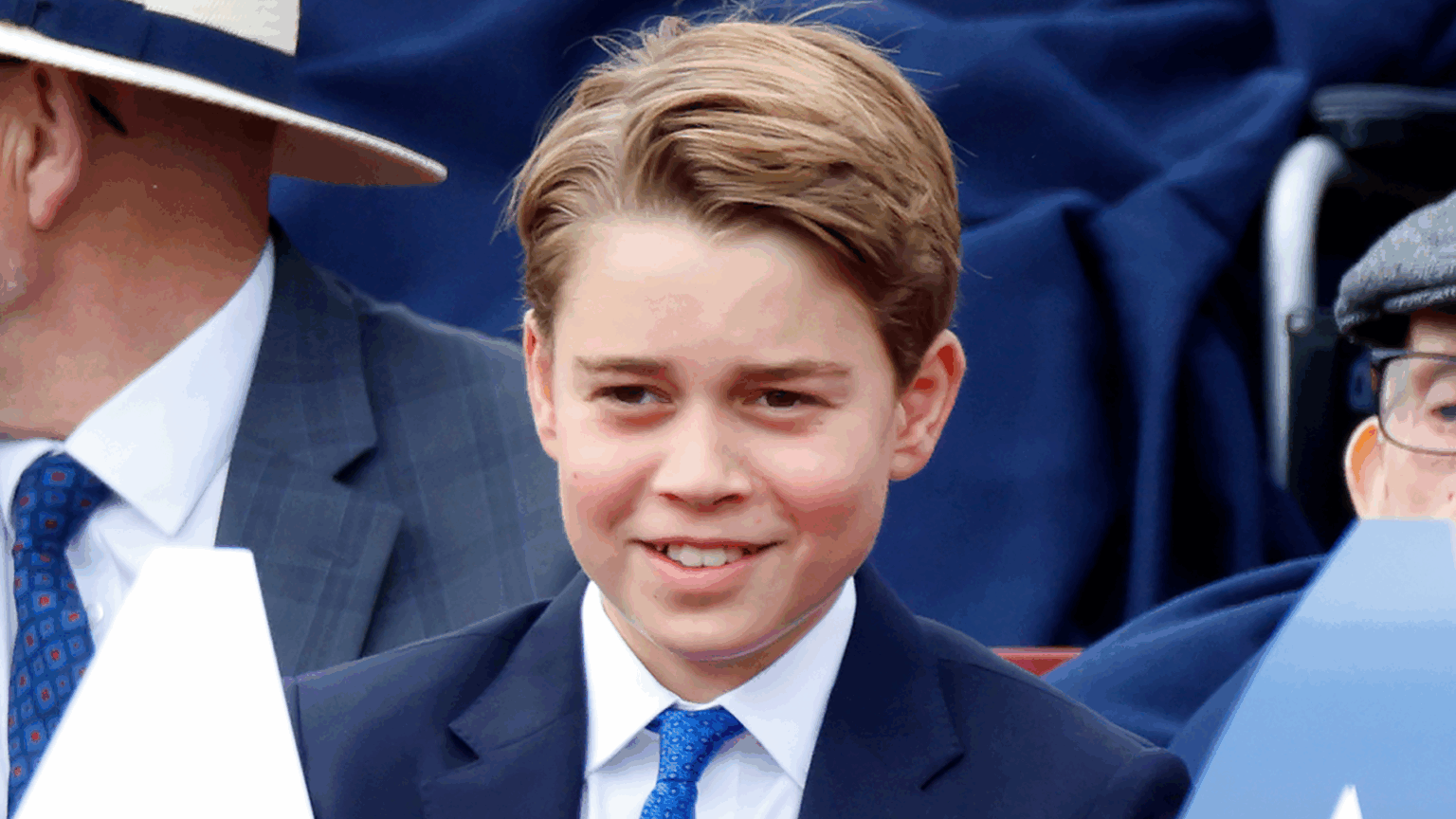 Former Royal Butler Says It Would Be “Very Strange” If Prince George “Stopped” One Royal “Tradition” Prince George wearing a blue suit and smiling