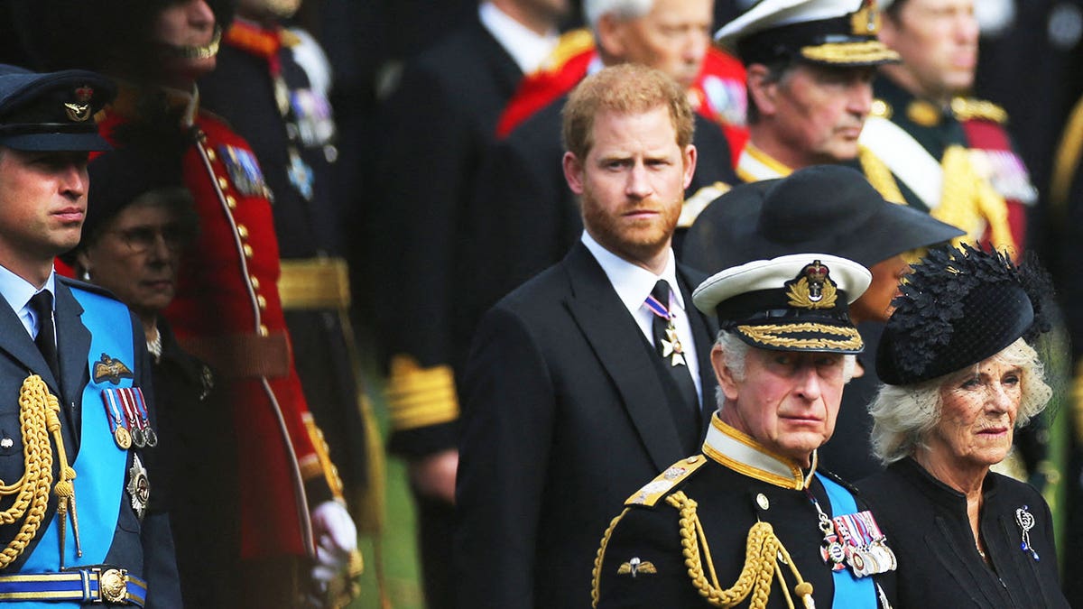 Prince Harry looking somber with his royal family.