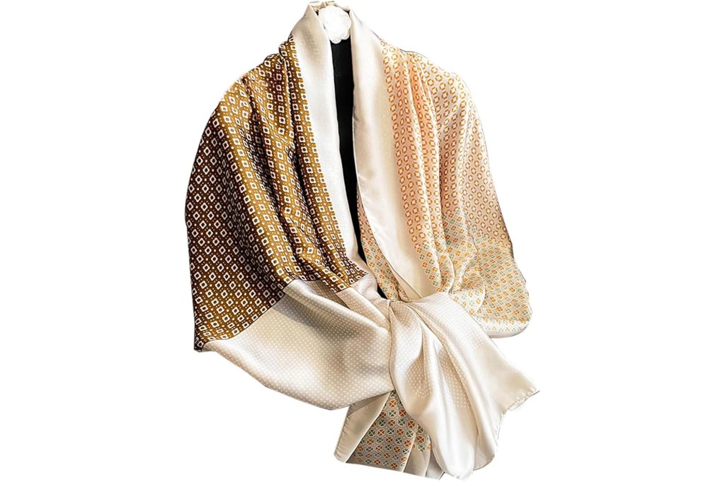 A patterned silk scarf in two tones, dark gold and light gold, with geometric patterns, tied in a knot.
