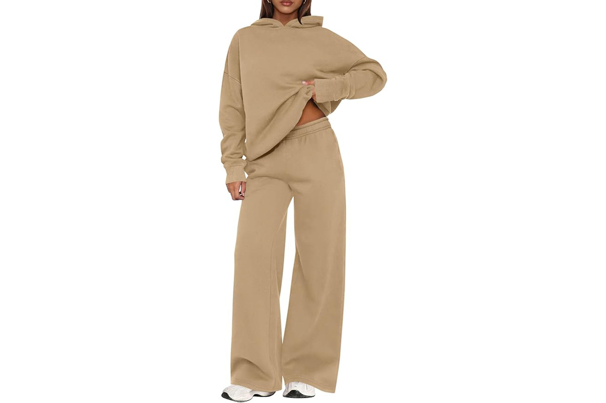 A model wearing a light brown sweatsuit with an oversized hoodie and loose pants.