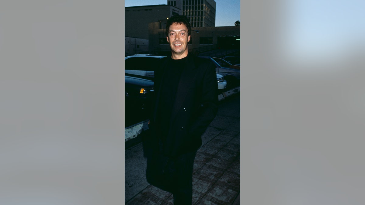 Tim Curry smiling for the camera during the '90s