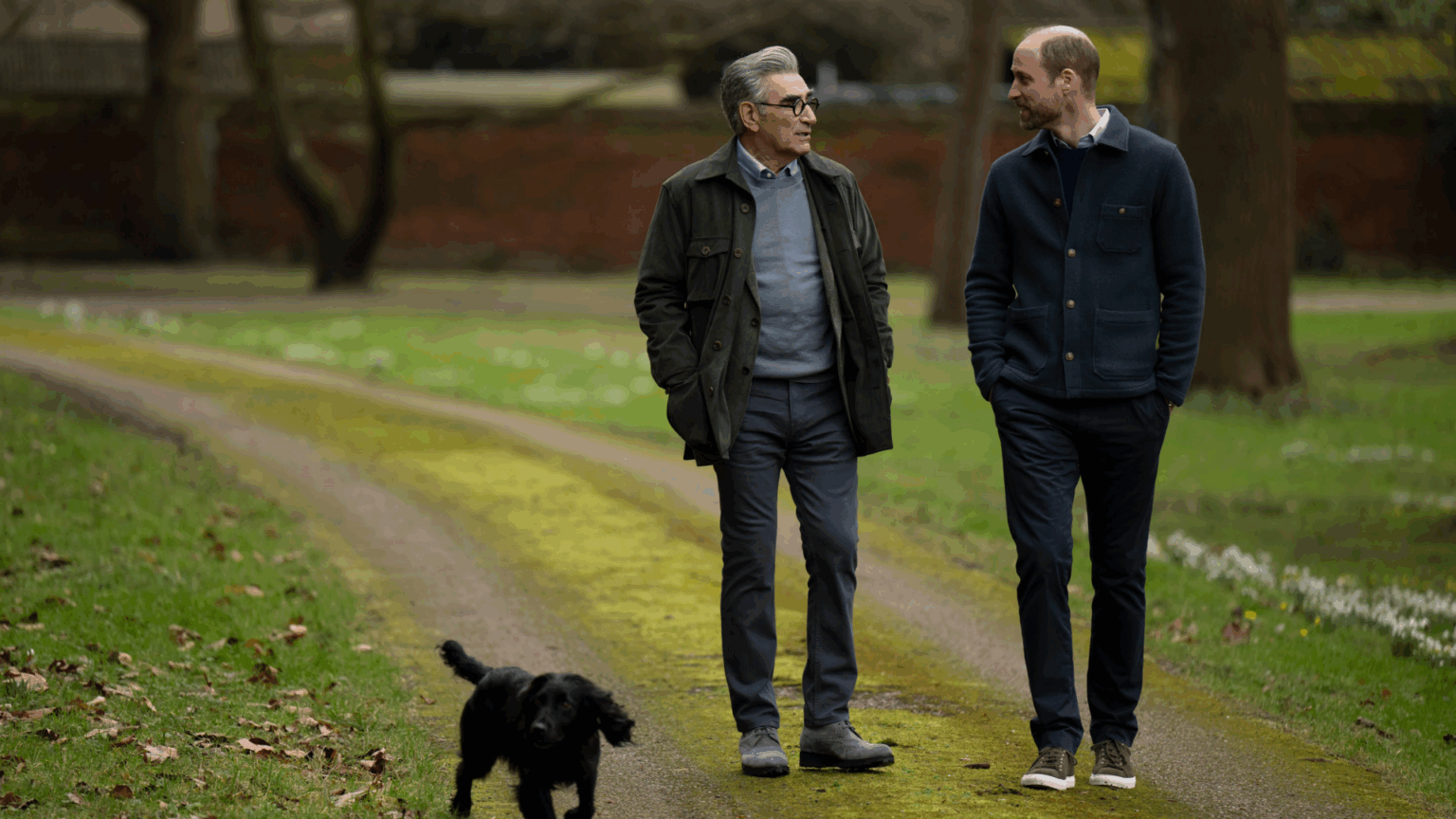 Prince William walking with Eugene Levy and Orla the dog through a park