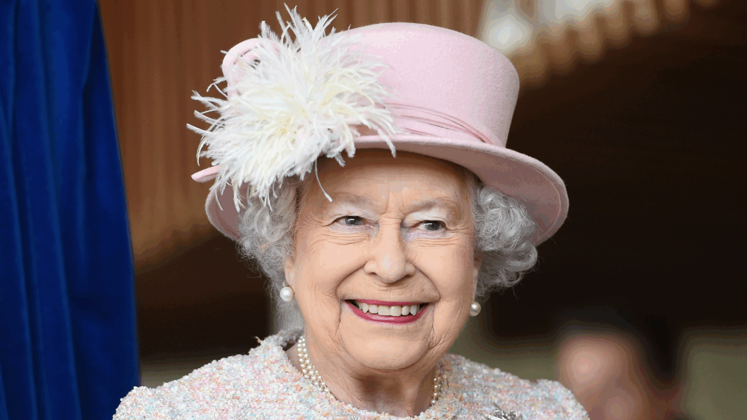 Queen Elizabeth’s Go-To Designer Shares the Touching Gesture and “Subtle Kindnesses” She Showed Towards Him Queen Elizabeth wearing a pink hat and coat smiling