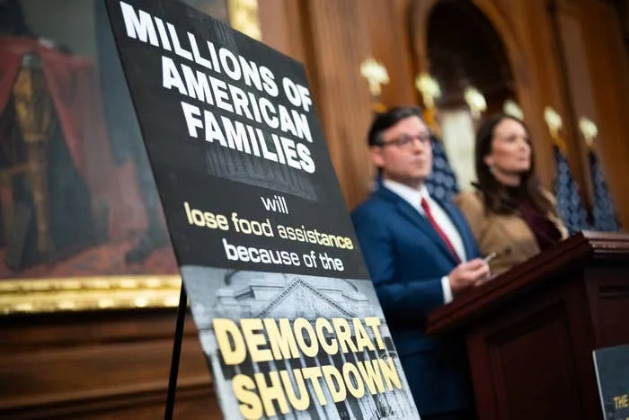 A podium photo with a sign reading "Millions of American families will lose food assistance because of the Democrat shutdown."