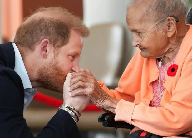 Harry gives veteran Villa Shah, 91, a kiss on the hands