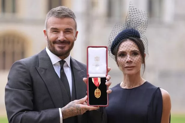 Sir David Beckham poses with his wife Lady Victoria after he was made a Knight Bachelor at an investiture ceremony at Windsor Castle. 