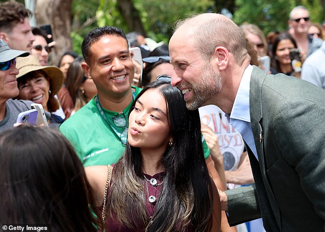 Prince William poses for pictures with royal fans in Rio de Janeiro on the first day of his Brazil visit on Monday