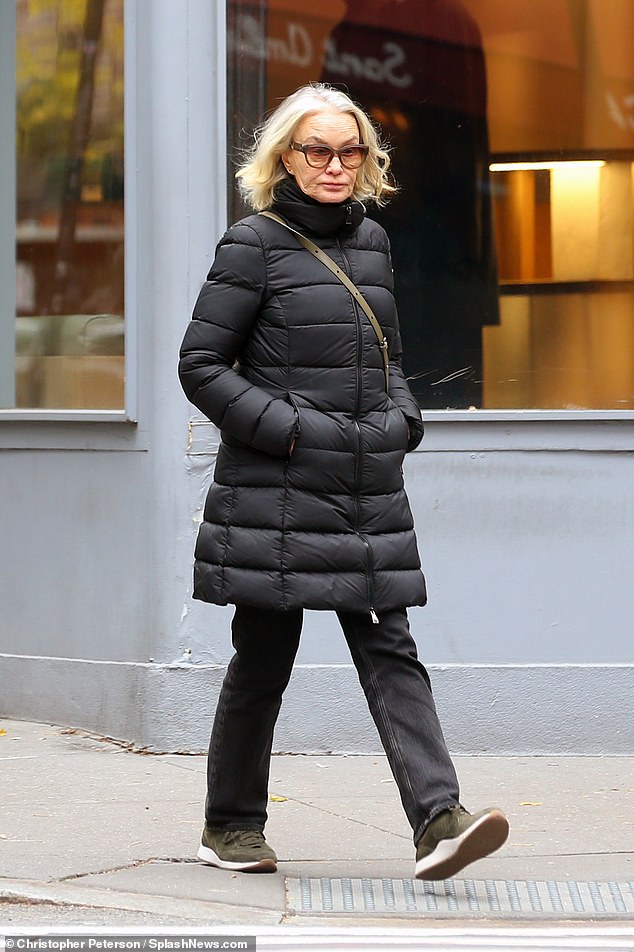 She a wore all black with a beige crossbody purse while picking up a green smoothie