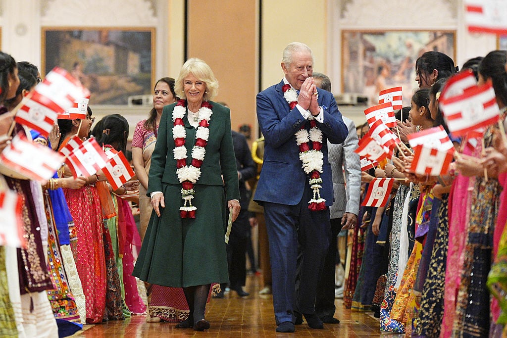 Two people walk between two rows of people.