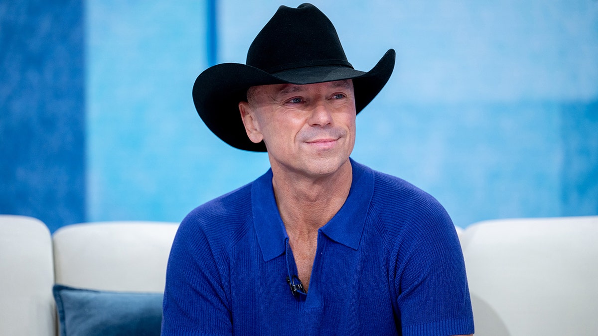 Kenney Chesney wears a cowboy hat with a blue shirt