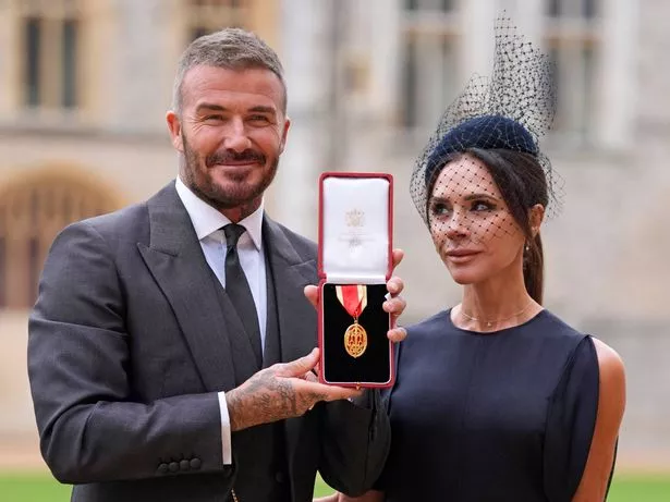 Sir David Beckham poses with his wife Lady Victoria after he was made a Knight Bachelor at an investiture ceremony at Windsor Castle on November 4, 2025 in Windsor, England