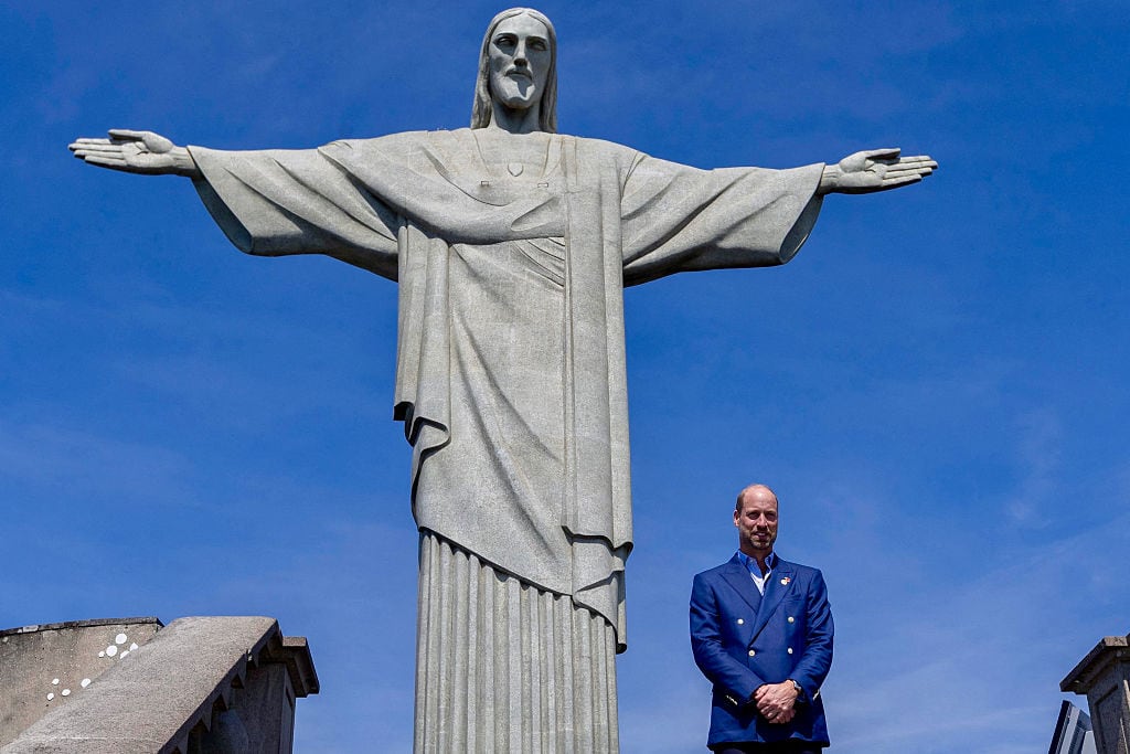 A person stands in front of a large statue.