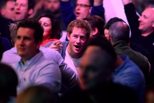 Prince Harry enjoys the darts match between Stephen Bunting of England and James Wade of England with friends during the William Hill PDC World Darts Championships on Day Nine at Alexandra Palace on December 29, 2014