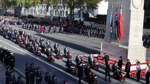 Reuters Veterans in mobility scootes going past the Cenotaph on Whitehall