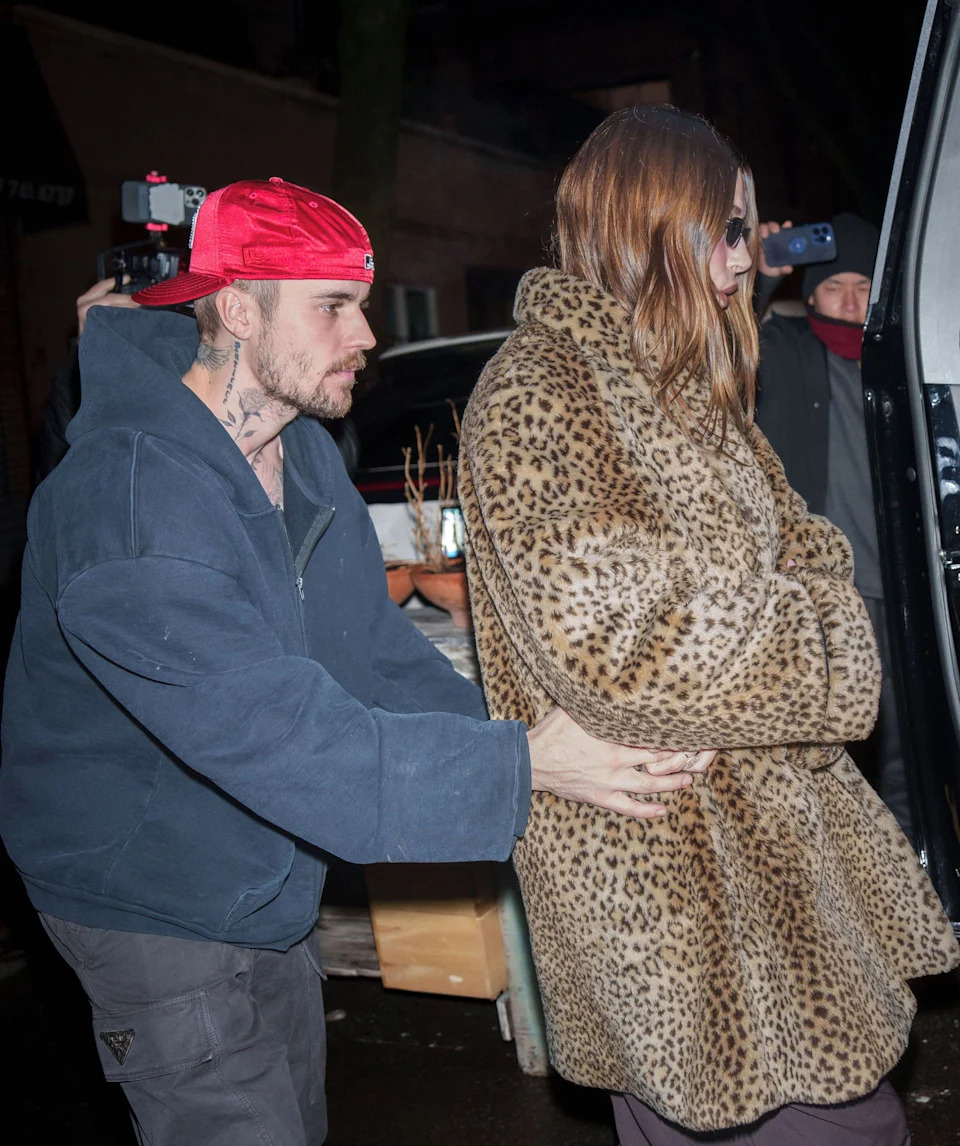 Justin Bieber escorts Hailey Bieber in a leopard print coat to a vehicle