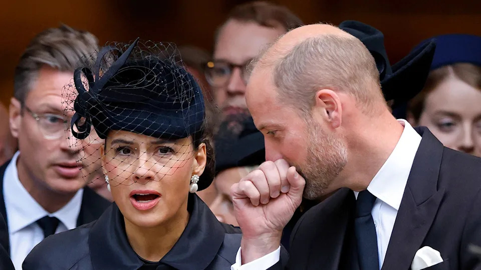 Prince William whispering something to Sophie Winkleman as she appears surprised.