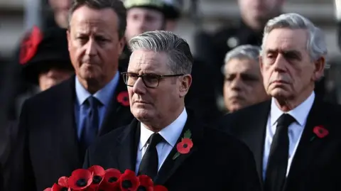 Getty Images Britain's Prime Minister Keir Starmer holds his wreath as former prime ministers David Cameron (back L) and Gordon Brown (back R).