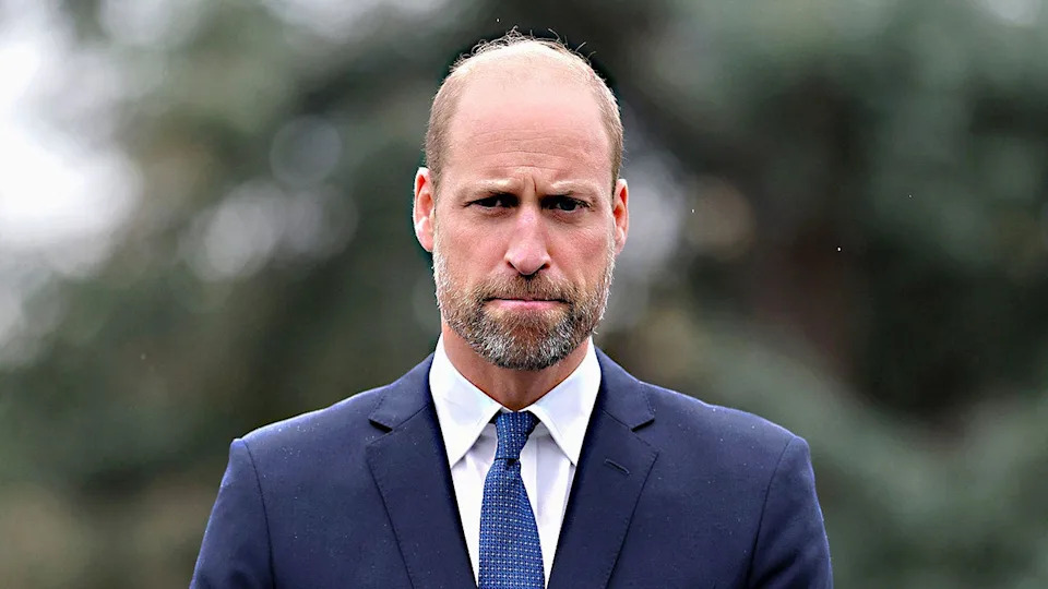 A close-up of Prince William in a dark blue suit looking pensive while completing a royal engagement.