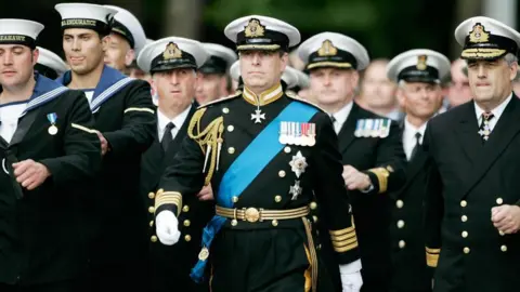 PA Media Andrew Mountbatten Windsor wearing a full military uniform marching alongside other Royal Navy personnel