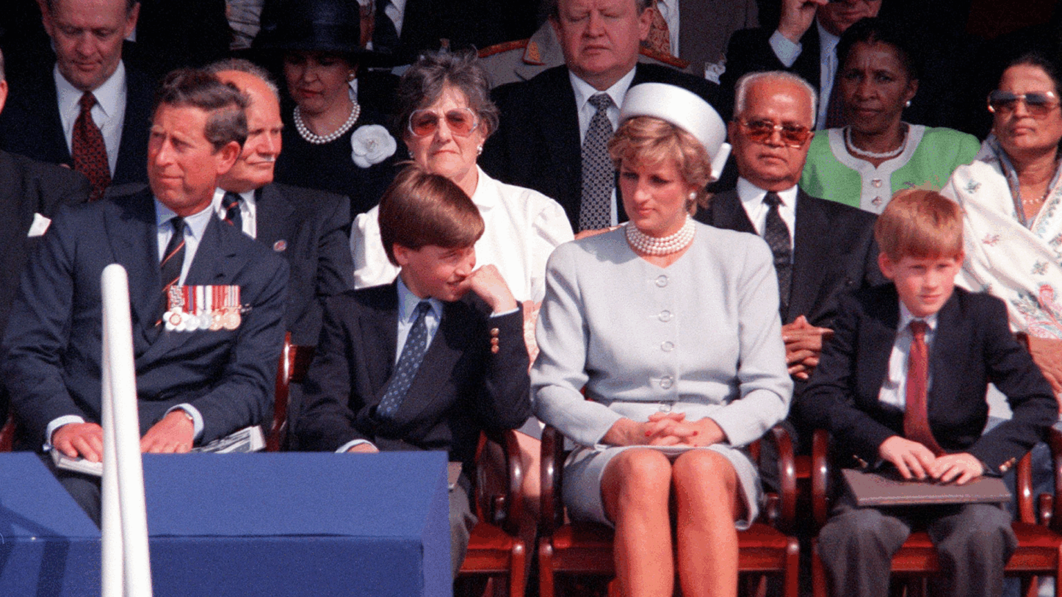 Prince Charles, Prince William, Princess Diana and Prince Harry sitting in a row in chairs