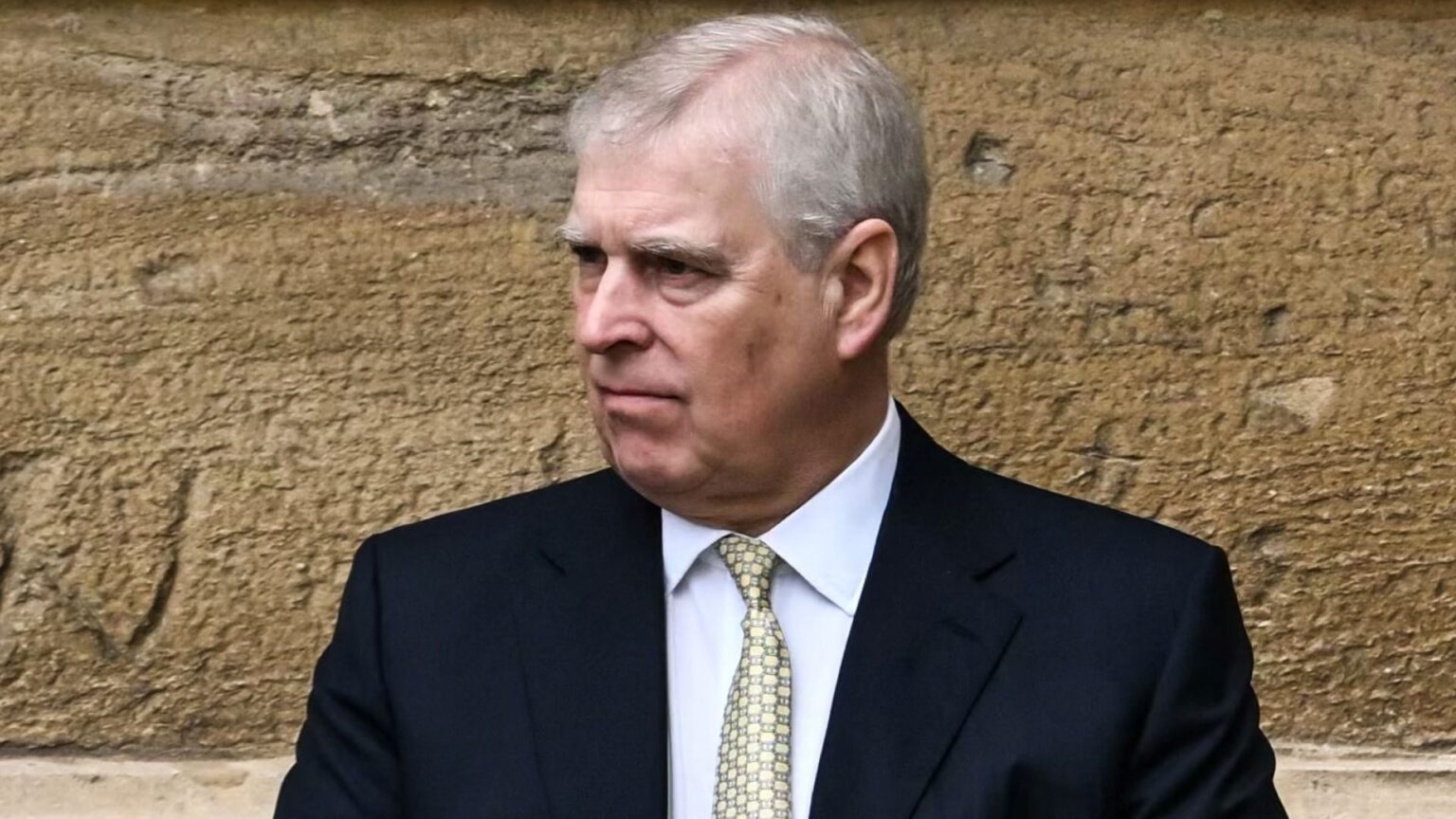 Royal Expert Says The King Needs to Make One Move to Avoid the “Unimaginable” Happening with the Former Prince Andrew Prince Andrew wearing a suit and tie looking angry standing in front of a concrete wall