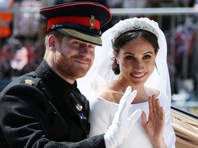 Prince Harry, Duke of Sussex, and his wife Meghan, Duchess of Sussex, wave from the Ascot Landau Carriage as they head back towards Windsor Castle in Windsor, England, after their wedding ceremony on May 19, 2018.