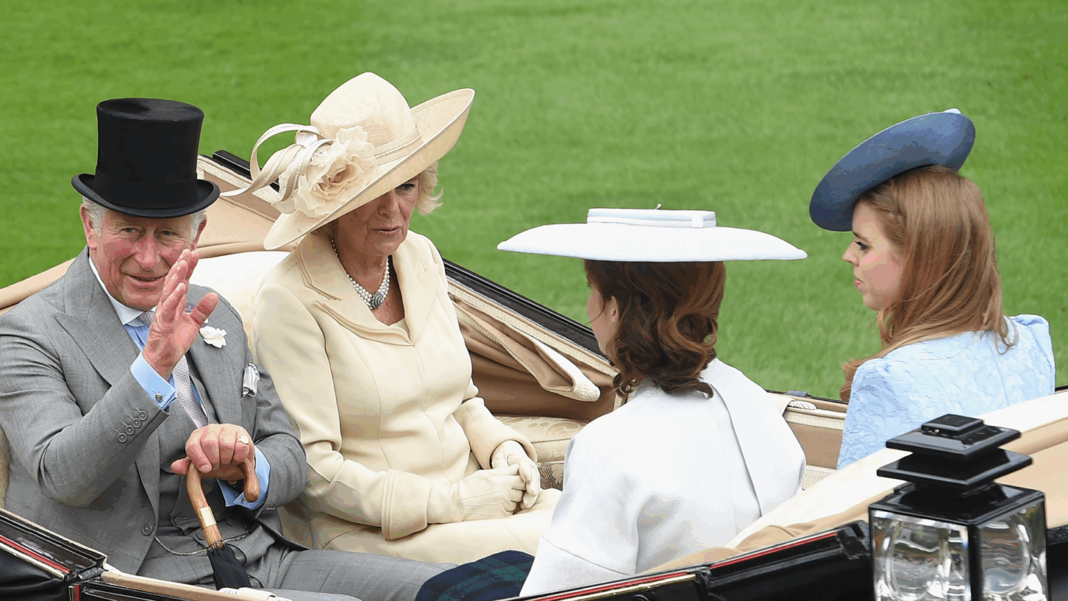 King Charles Is “Concerned” That “The Sins of the Family” Will Impact Princess Beatrice and Princess Eugenie King Charles riding in a carriage waving with Queen Camilla, Princess Eugenie and Princess Beatrice