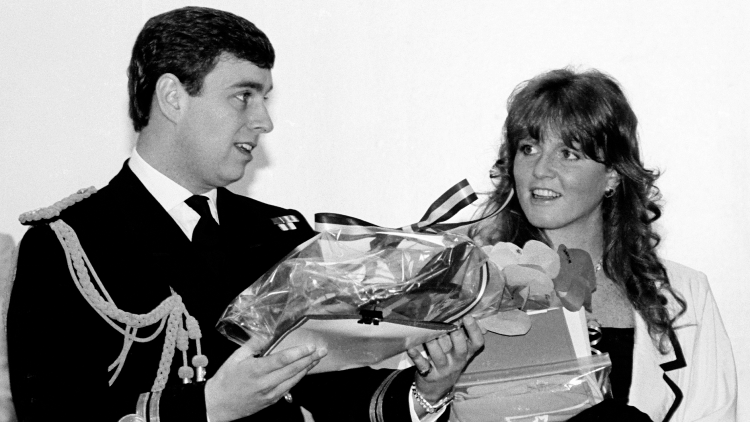 Pregnant Sarah Ferguson Invited Her Lover to Husband Andrew’s 30th Birthday Party at Buckingham Palace—And Queen Elizabeth Weighed In Prince Andrew wearing a naval uniform holding gifts smiling next to Sarah Ferguson
