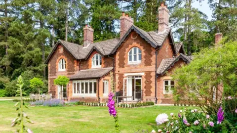 Oliver's Travels The Gardens House on the Sandringham estate. It is a two-floor red brick house with white-panelled windows.