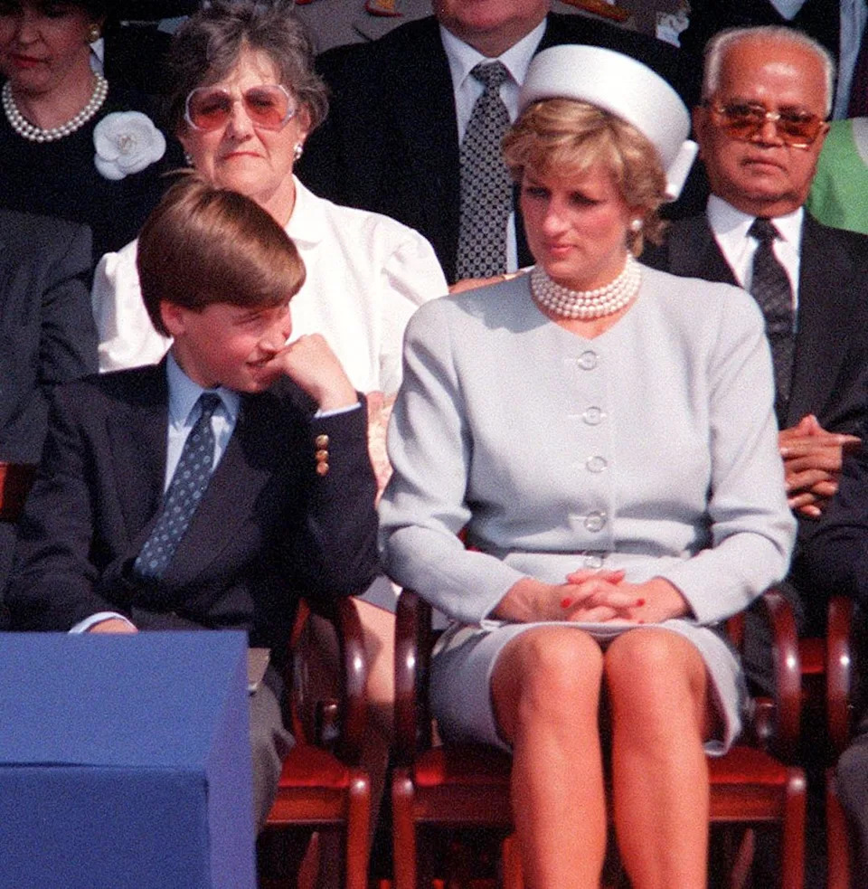  Prince Charles, Prince William, Princess Diana and Prince Harry sitting in a row in chairs. 