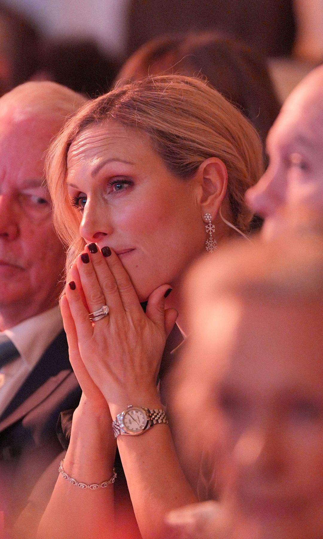 Zara Tindall with her hands by her mouth as she sits with Mike Tindall