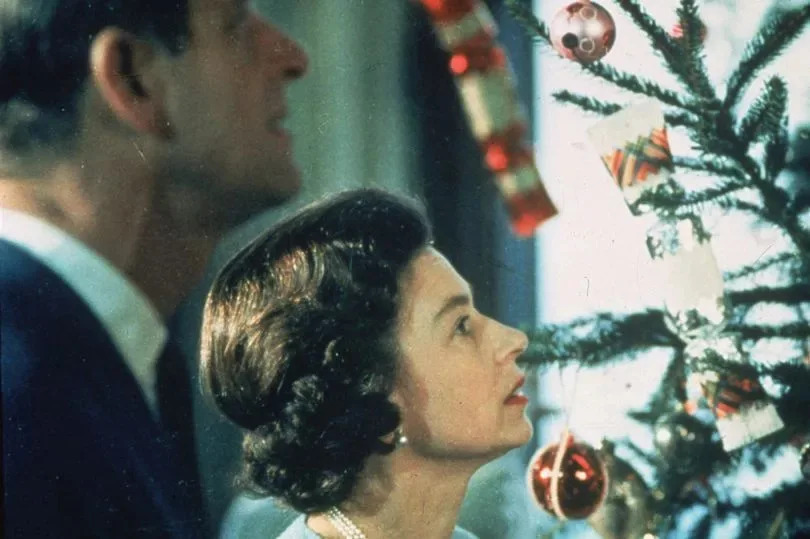 Queen Elizabeth II and Prince Philip look at their decorated Christmas tree during the filming of a television special about life in the British royal family