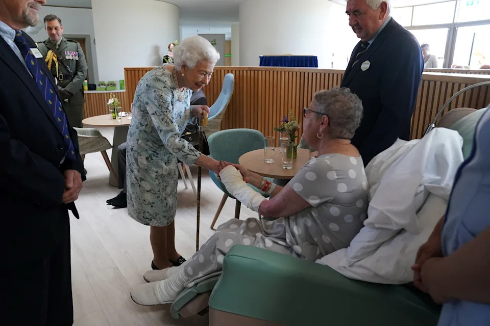 Queen Elizabeth shaking hands with a hospice patient