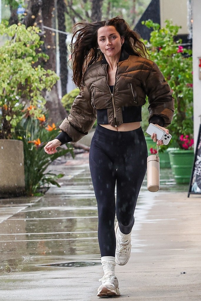 Ana de Armas runs through the rain on her way to a Santa Monica gym.