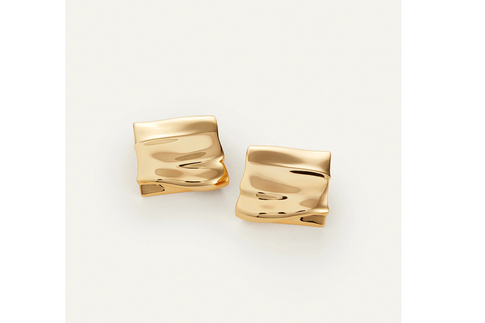 Two gold-toned, rectangular earrings with an uneven, wavy texture on a white background.