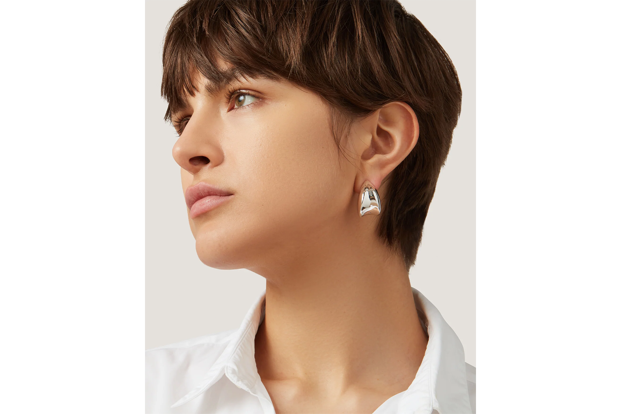 Close up of a person wearing the Jenny Bird Black Friday gold earrings.