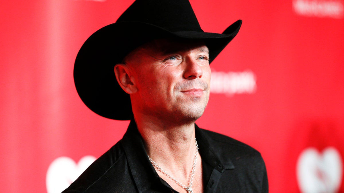 Country singer Kenny Chesney wearing a black cowboy hat and shirt
