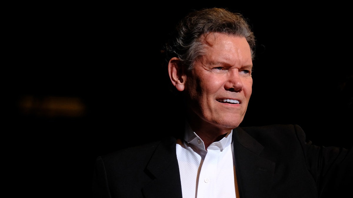Randy Travis smiles on stage