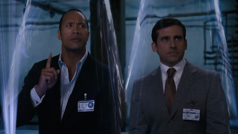 Dwayne Johnson as Agent 23 stands next to Steve Carell as Maxwell Smart as they stand in cones of silence in Get Smart