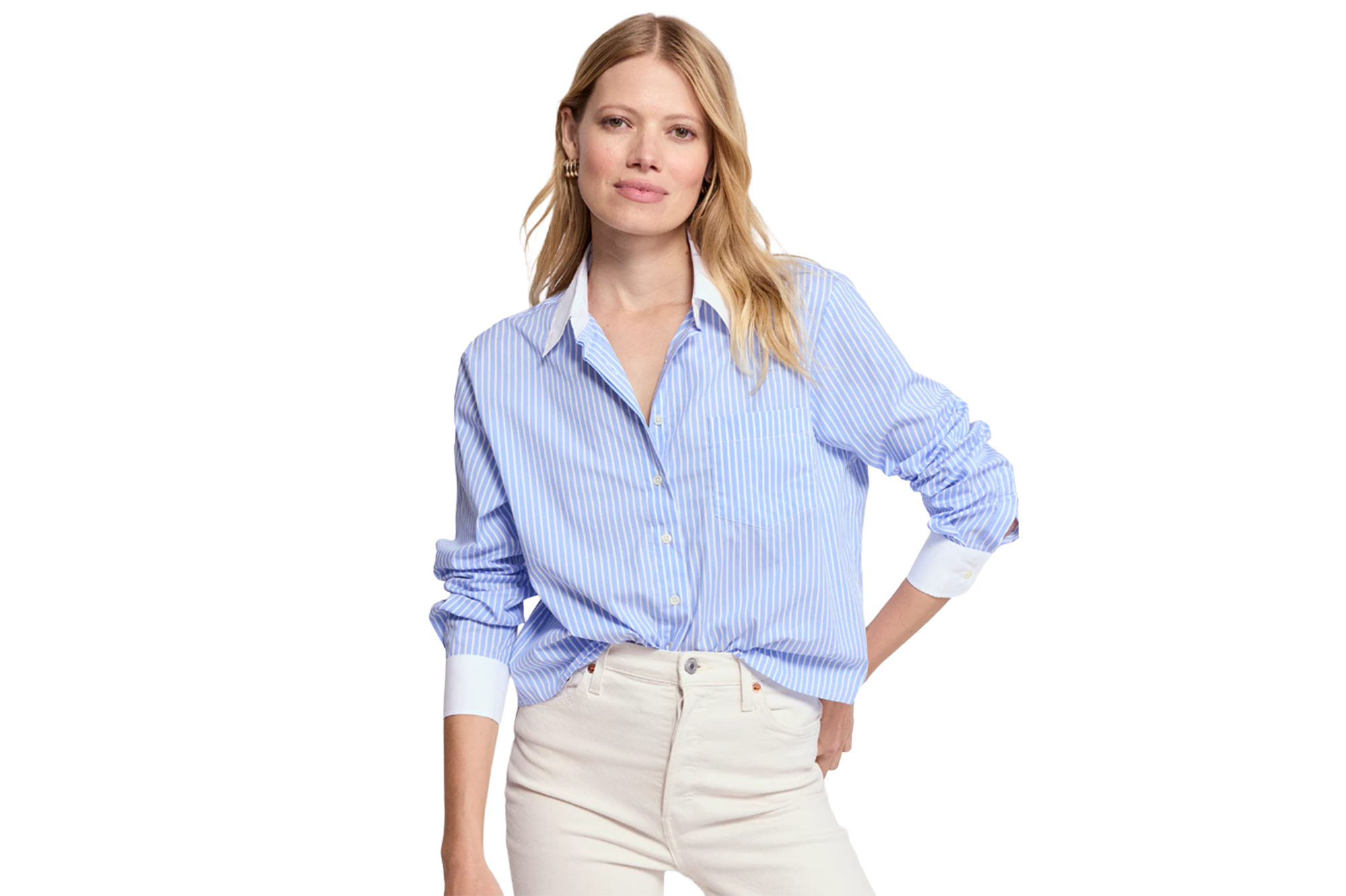A woman wearing a light blue and white striped shirt and cream-colored pants.
