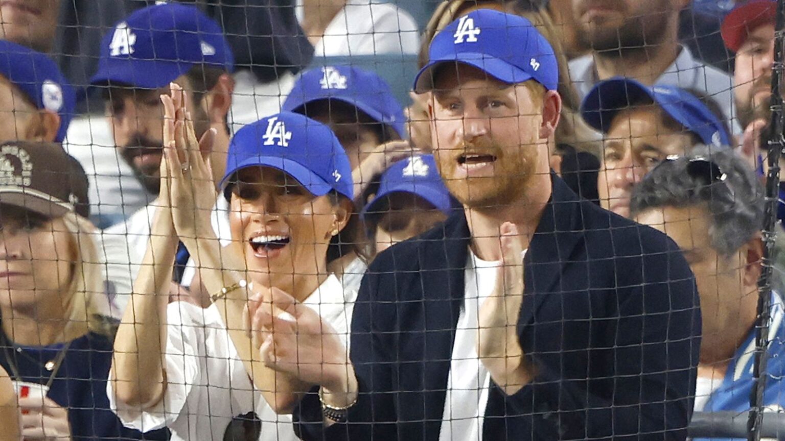 Prince Harry apologises to Canada for wearing LA Dodgers cap at World Series | World News Prince Harry and his wife, Meghan, in LA Dodgers caps at the game. Pic: John Angelillo/UPI/Shutterstock