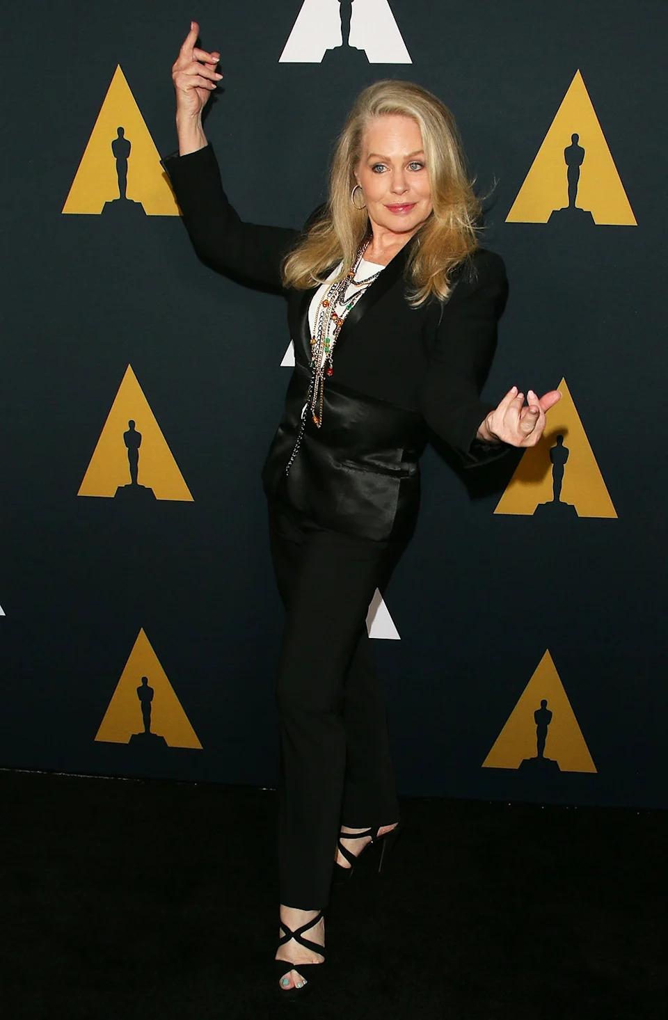 Beverly D'Angelo striking a pose in a black outfit.