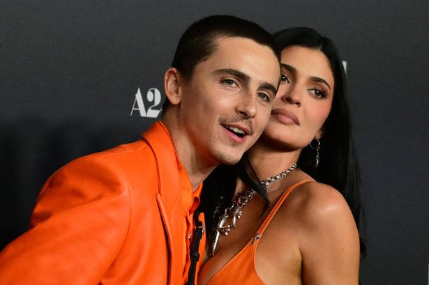 Chalomet and jenner in bright orange on red carpet